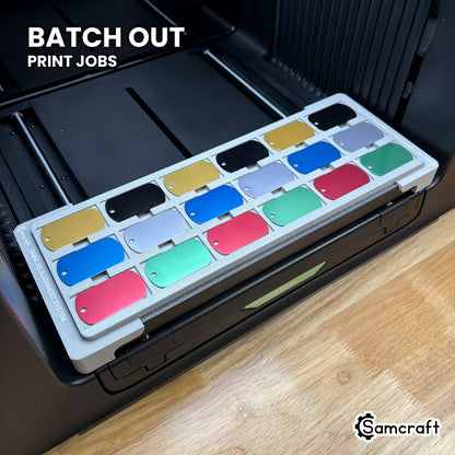 Samcraft military dog tag jig filled with eighteen anodized tags on the xTool Omni UV printer, ready to batch out print jobs.