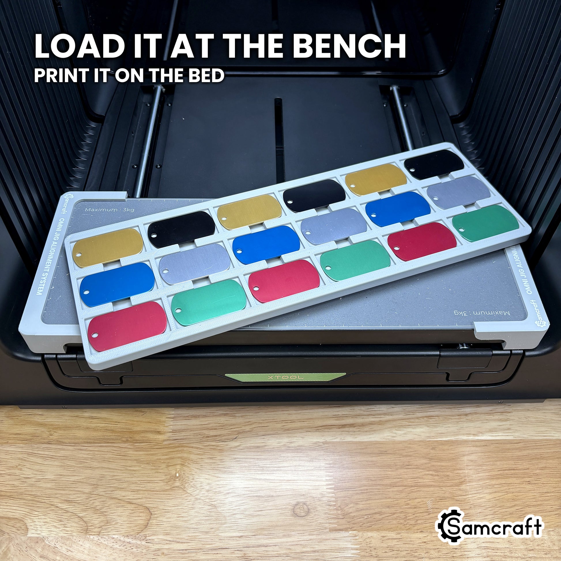 The loaded Samcraft military dog tag jig lifted at an angle above the xTool Omni bed, showing it can be filled away from the machine and set down to print.