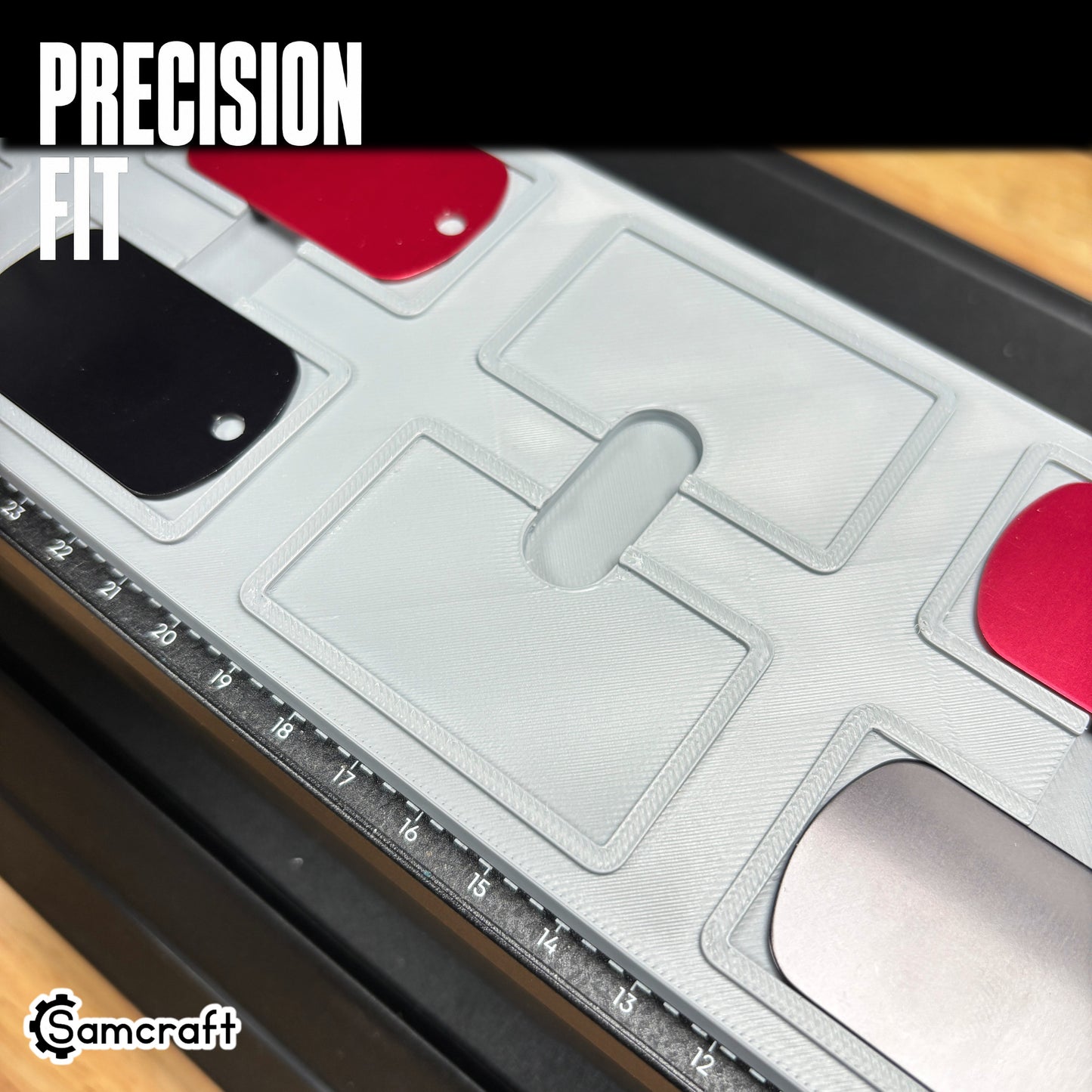 Angled view of the Samcraft dog tag jig holding red, pink, blue, purple, and black aluminum tags in a heat-resistant gray tray on the eufyMake E1 printer.
