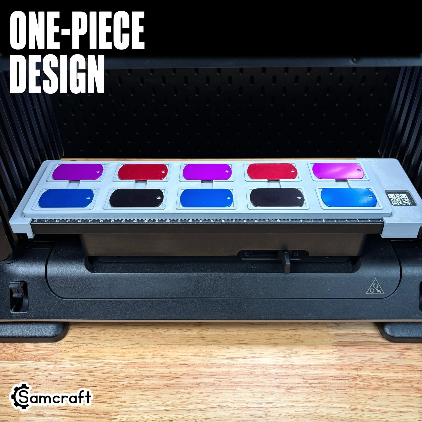 Front view of the one-piece Samcraft Military Dog Tag Jig with two rows of red, purple, blue, and black dog tags arranged on the eufyMake E1 UV printer.