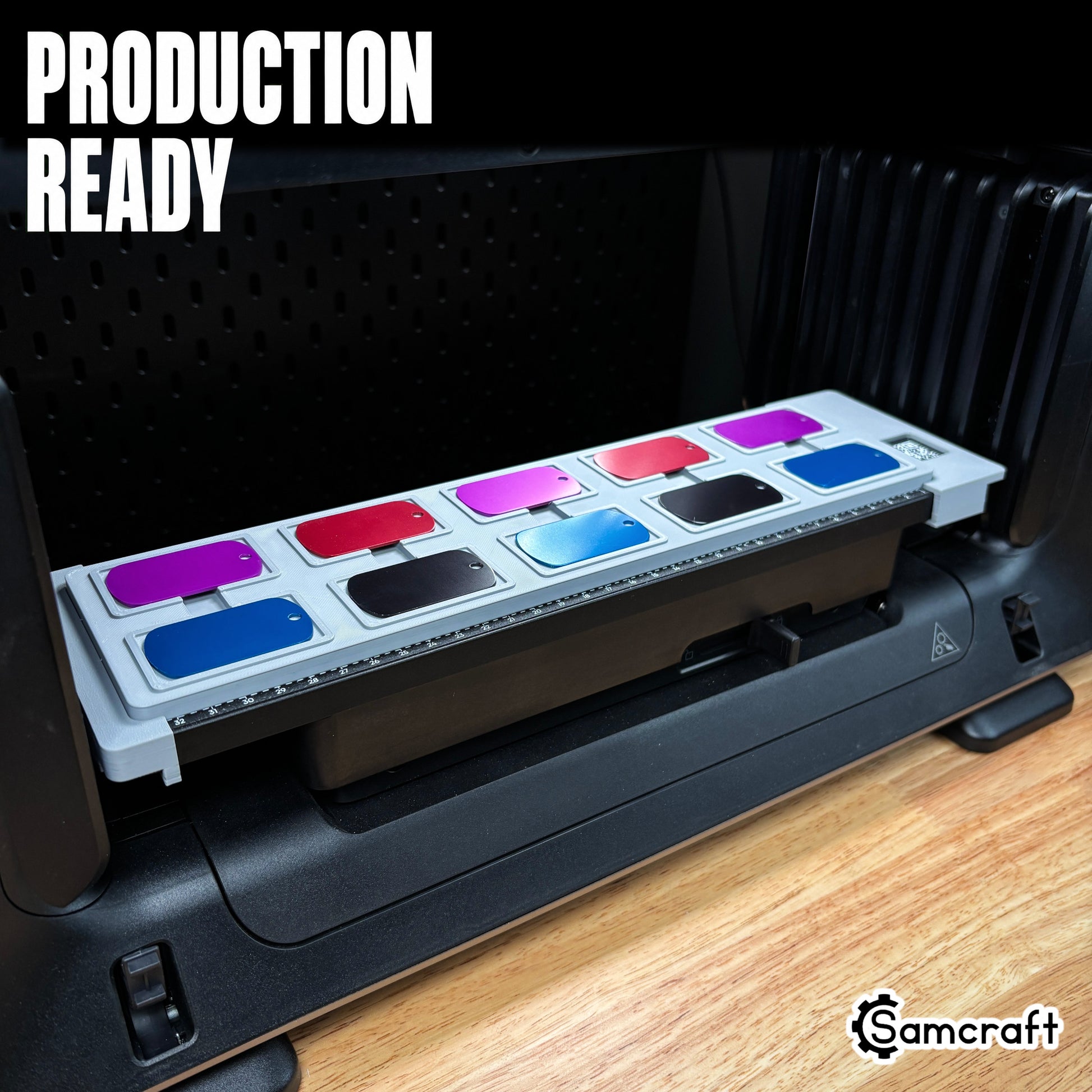 Full view of the Samcraft Military Dog Tag Jig loaded with ten colorful anodized dog tags, mounted on the eufyMake E1 UV printer bed, labeled "Production Ready."
