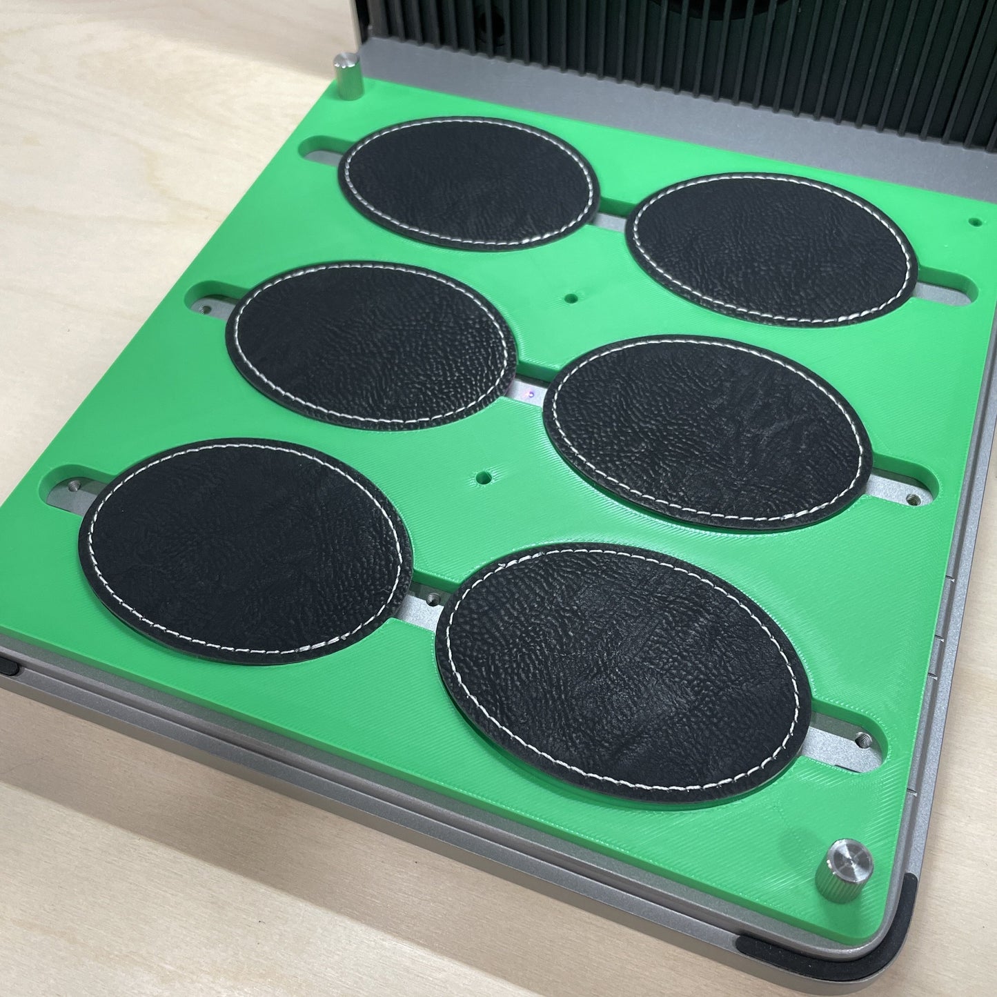 Samcraft green oval patch jig in an xTool F1 Ultra laser bed, holding four dark oval leatherette patches.