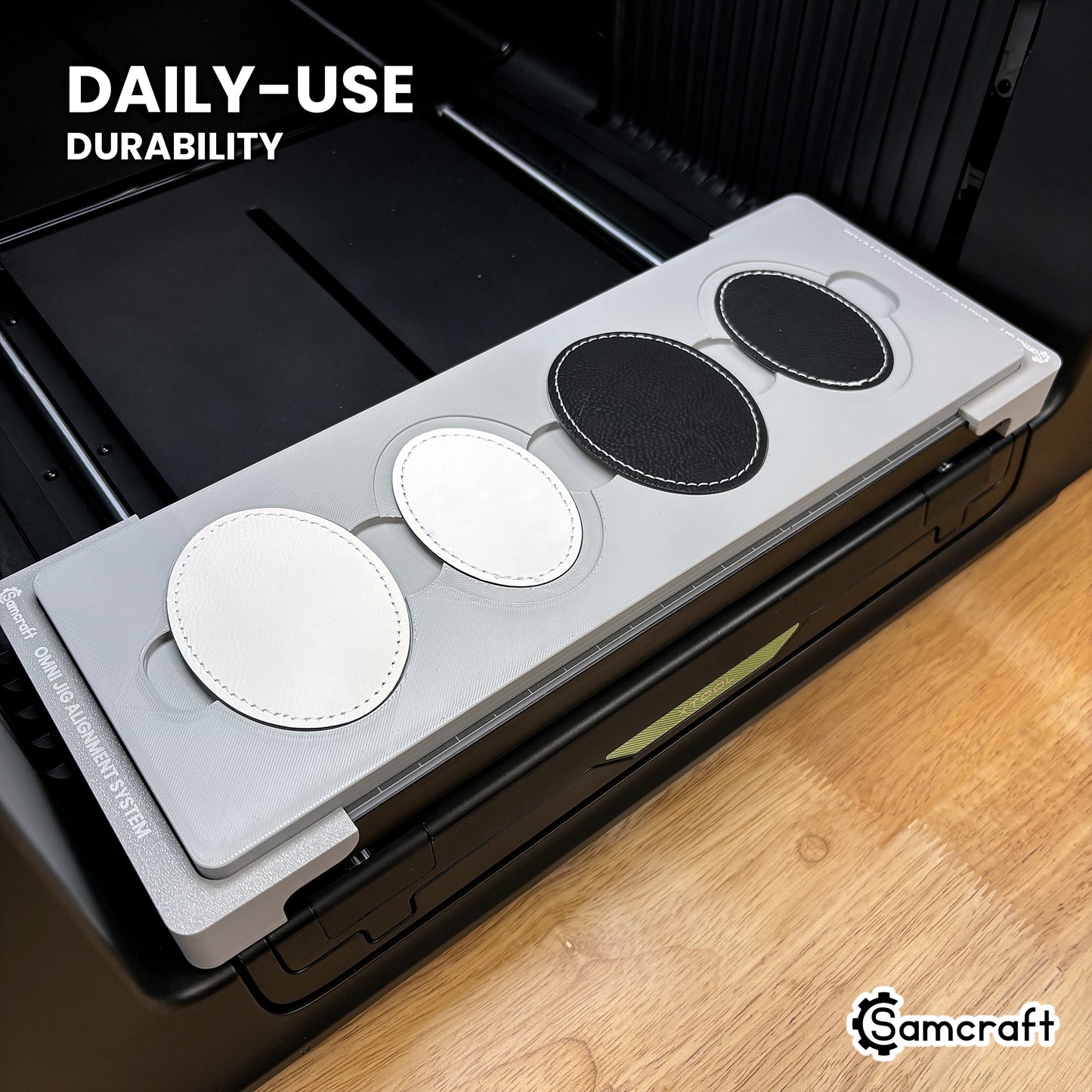 Samcraft patch jig in high-temperature rated plastic holding leatherette oval patches on the xTool Omni bed, built for daily-use durability.