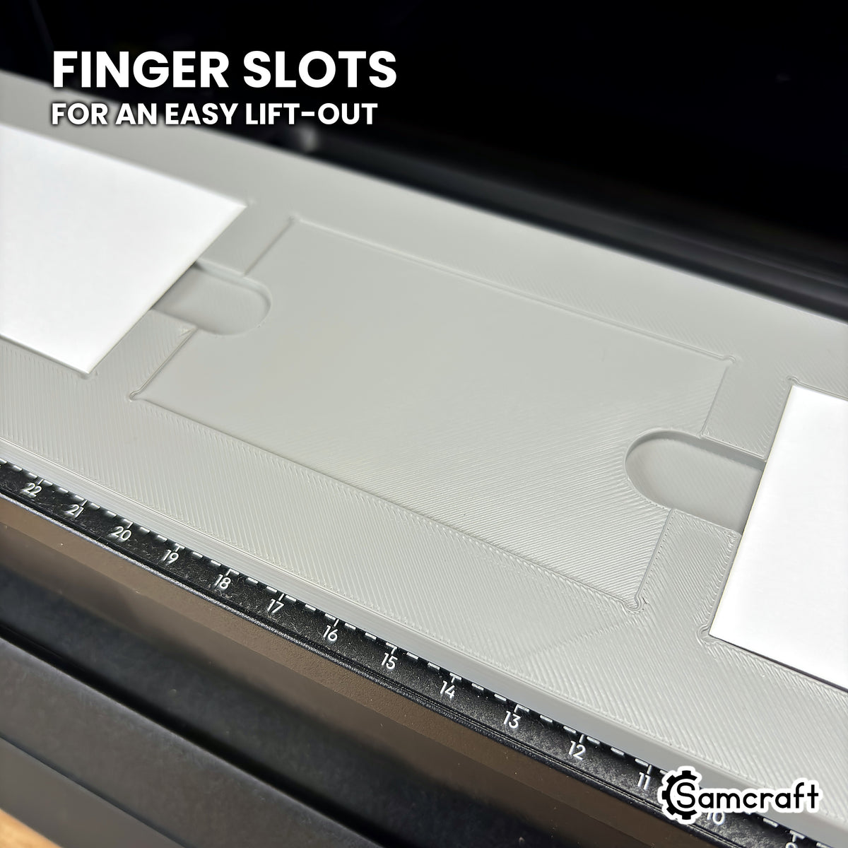 Close-up of the Samcraft eufyMake E1 paper business card jig with the center pocket empty, showing the finger slots on each side for lifting cards out.