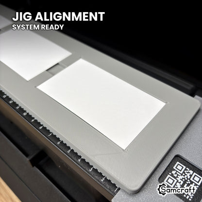 Close-up of the Samcraft paper business card jig seated against the eufyMake E1 Jig Alignment System end piece, with its QR code label visible.
