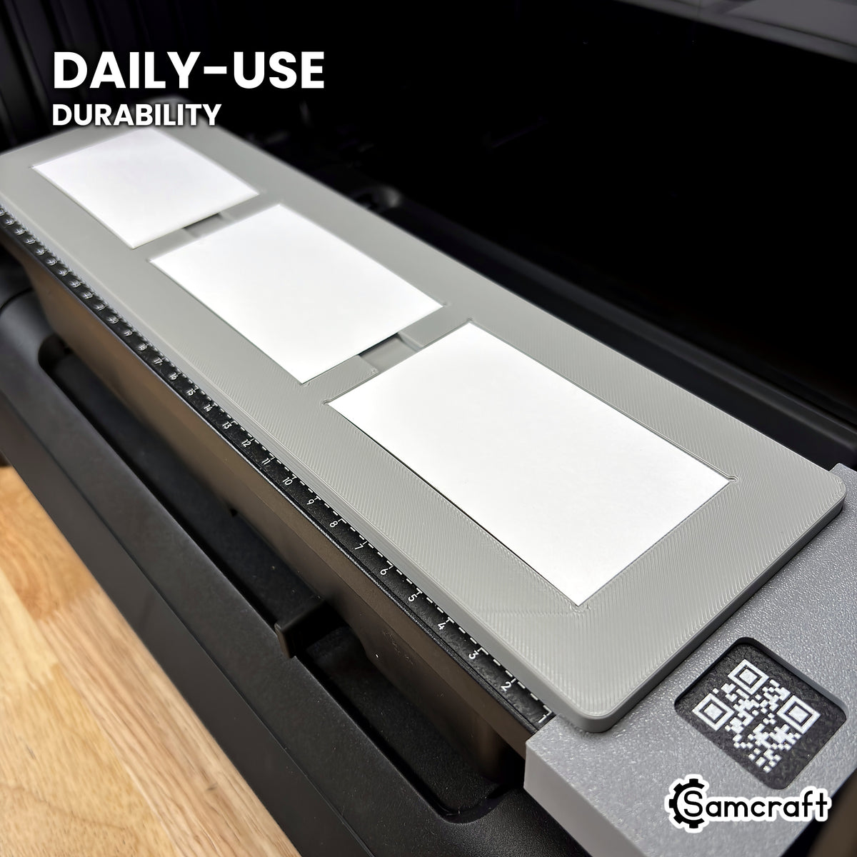 Samcraft eufyMake E1 paper business card jig loaded with cards, shown at an angle to highlight its solid one-piece build.