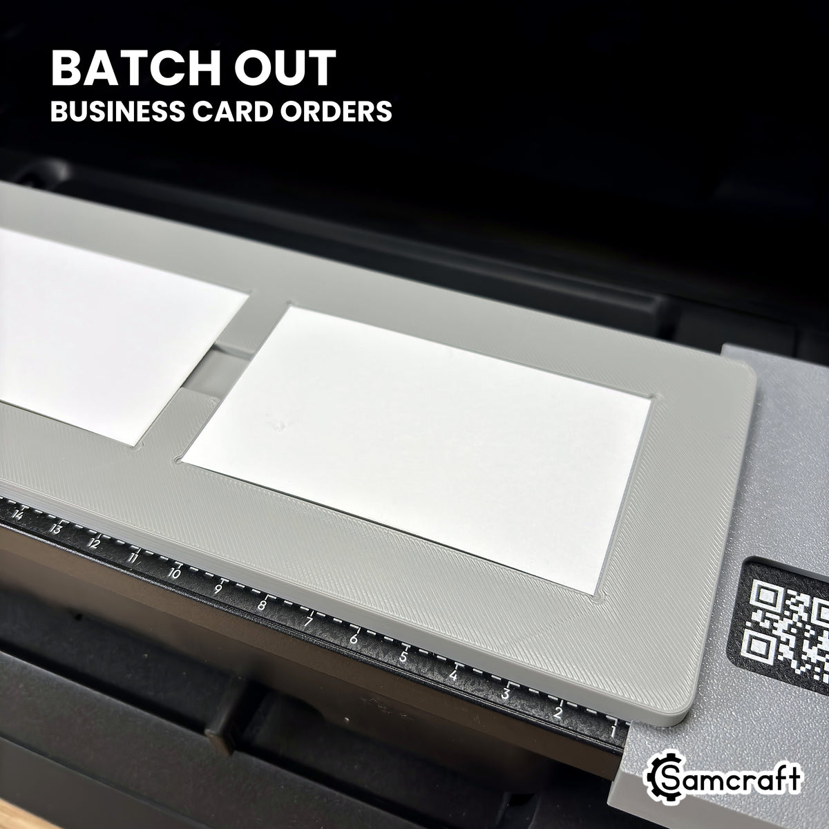 Close-up of business cards loaded in the Samcraft paper business card jig on the eufyMake E1, ready to batch out business card orders.