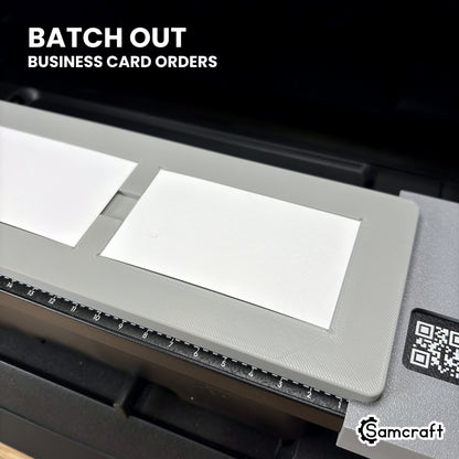 Close-up of business cards loaded in the Samcraft paper business card jig on the eufyMake E1, ready to batch out business card orders.