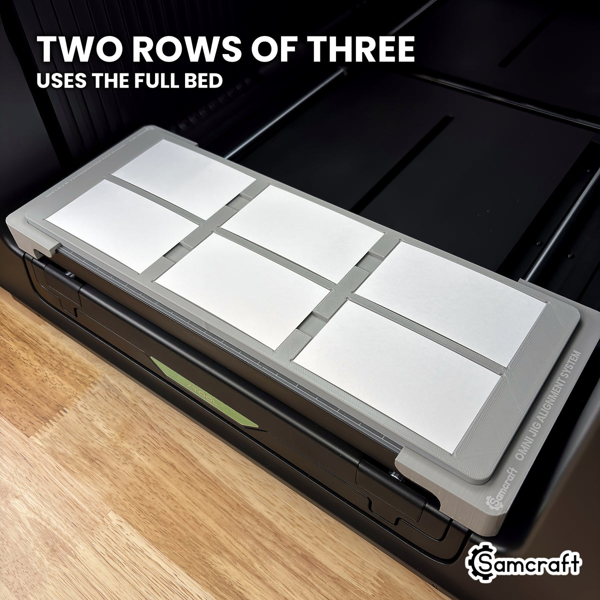 Angled view of the Samcraft xTool Omni paper business card jig showing two rows of three cards across the full width of the bed.