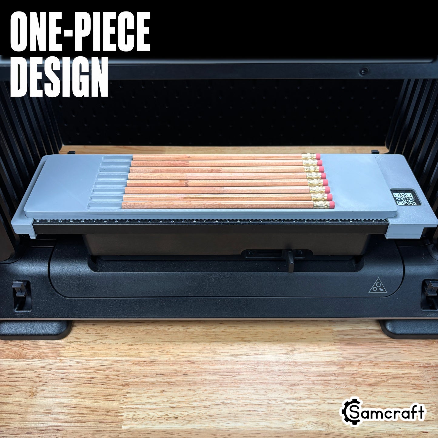 Front view of the one-piece Samcraft Pencil Jig loaded with wooden pencils on the eufyMake E1 UV printer, showing the gray tray and built-in ruler.