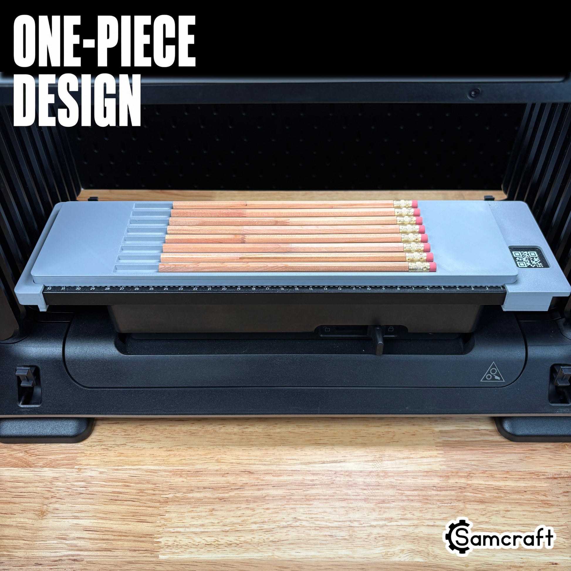 Front view of the one-piece Samcraft Pencil Jig loaded with wooden pencils on the eufyMake E1 UV printer, showing the gray tray and built-in ruler.