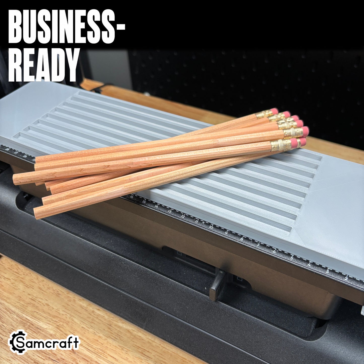 Business-ready Samcraft Pencil Jig with a bundle of wooden pencils resting on the gray tray's parallel channels on the eufyMake E1 UV printer.
