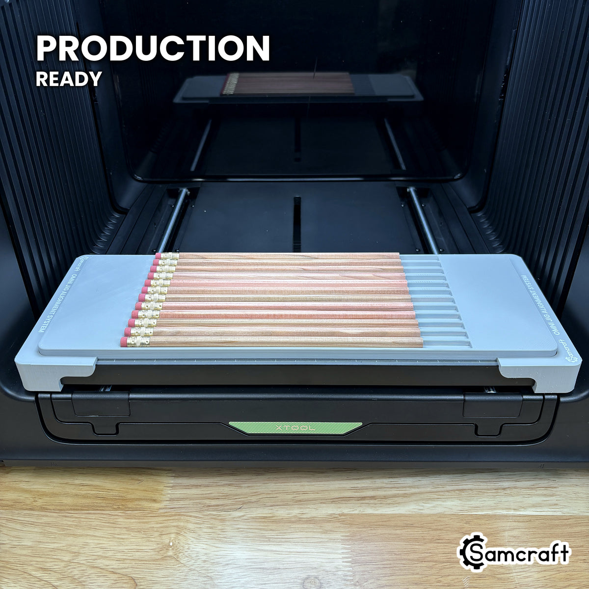 Samcraft hexagon pencil jig loaded with twelve pencils on the xTool Omni printer bed, set up for production runs.