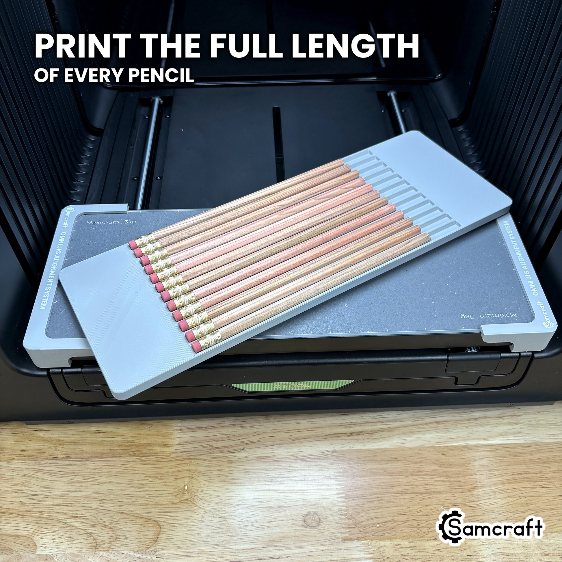 Angled view of twelve hexagon pencils lying full length in the Samcraft xTool Omni jig, one flat facet turned up toward the print head.