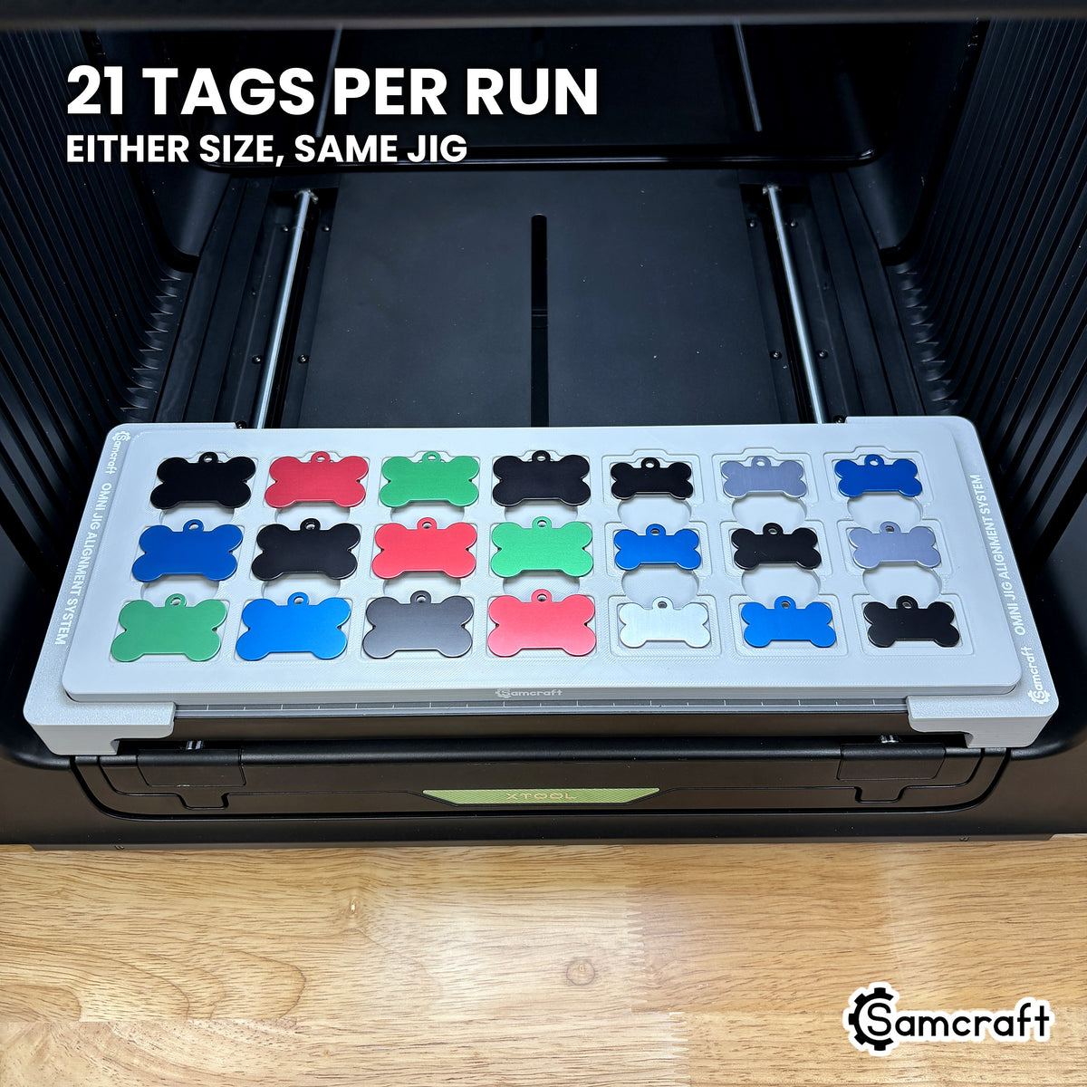 Samcraft bone pet tag jig loaded with 21 aluminum bone tags in seven columns of three, a full run in a single pass on the xTool Omni.