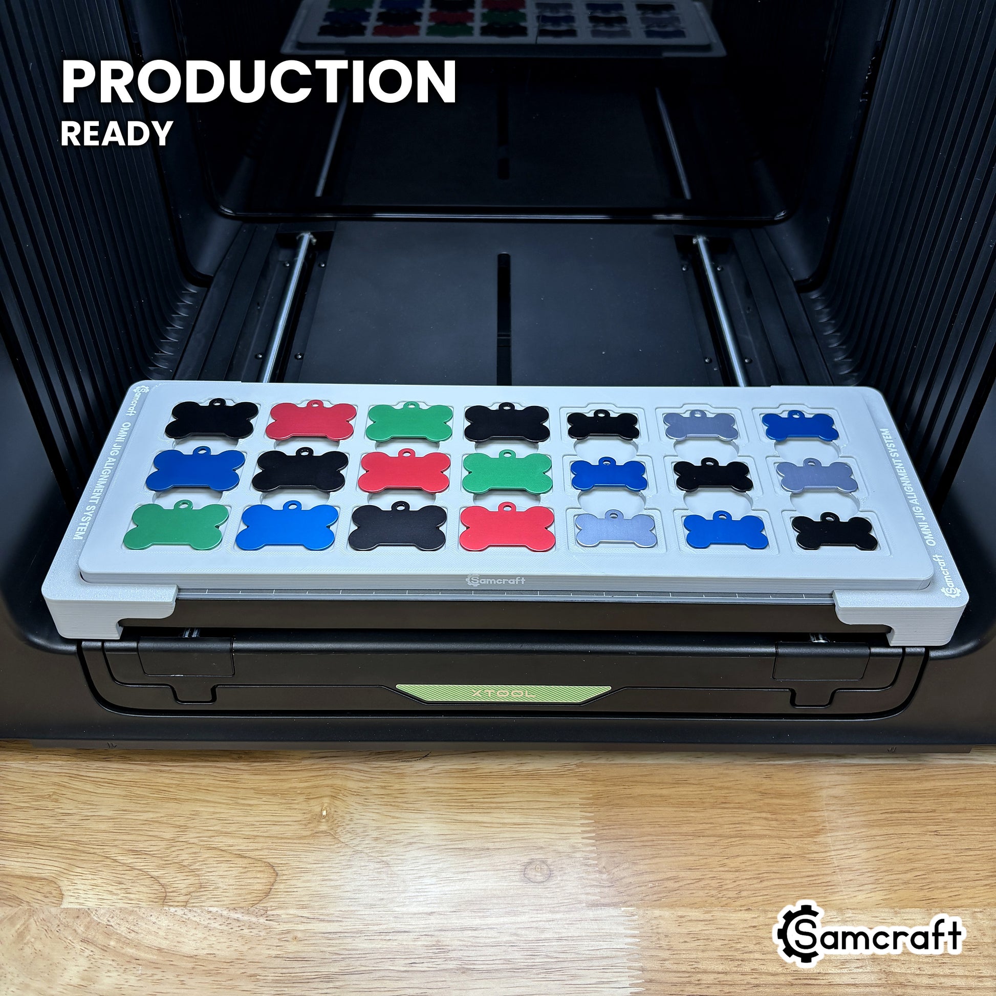 Samcraft bone pet tag jig holding 21 aluminum bone tags on the xTool Omni UV printer bed, set up for production runs.