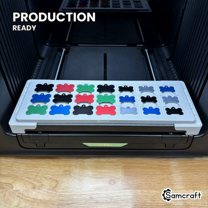 Samcraft bone pet tag jig holding 21 aluminum bone tags on the xTool Omni UV printer bed, set up for production runs.
