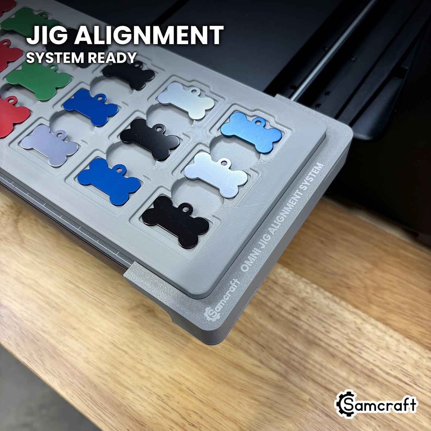 Close-up of the Samcraft bone pet tag jig seated on the Omni Jig Alignment System, the alignment system lettering visible along the edge.