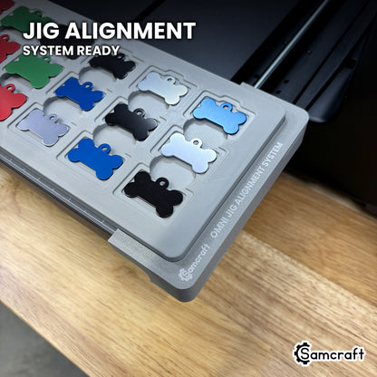 Close-up of the Samcraft bone pet tag jig seated on the Omni Jig Alignment System, the alignment system lettering visible along the edge.