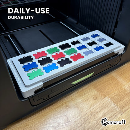 Samcraft bone pet tag jig in high-temperature rated plastic holding aluminum bone tags on the xTool Omni bed, built for daily-use durability.
