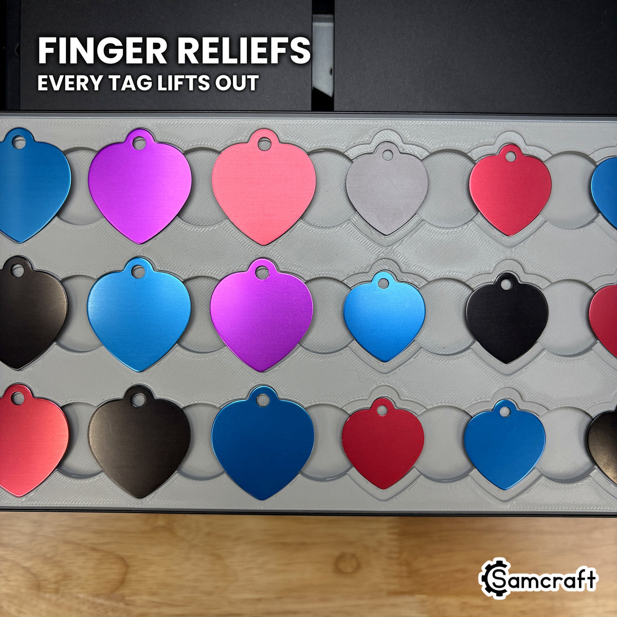 Close-up of the shared finger reliefs cut into the row walls of the Samcraft heart pet tag jig, so every tag lifts straight out.