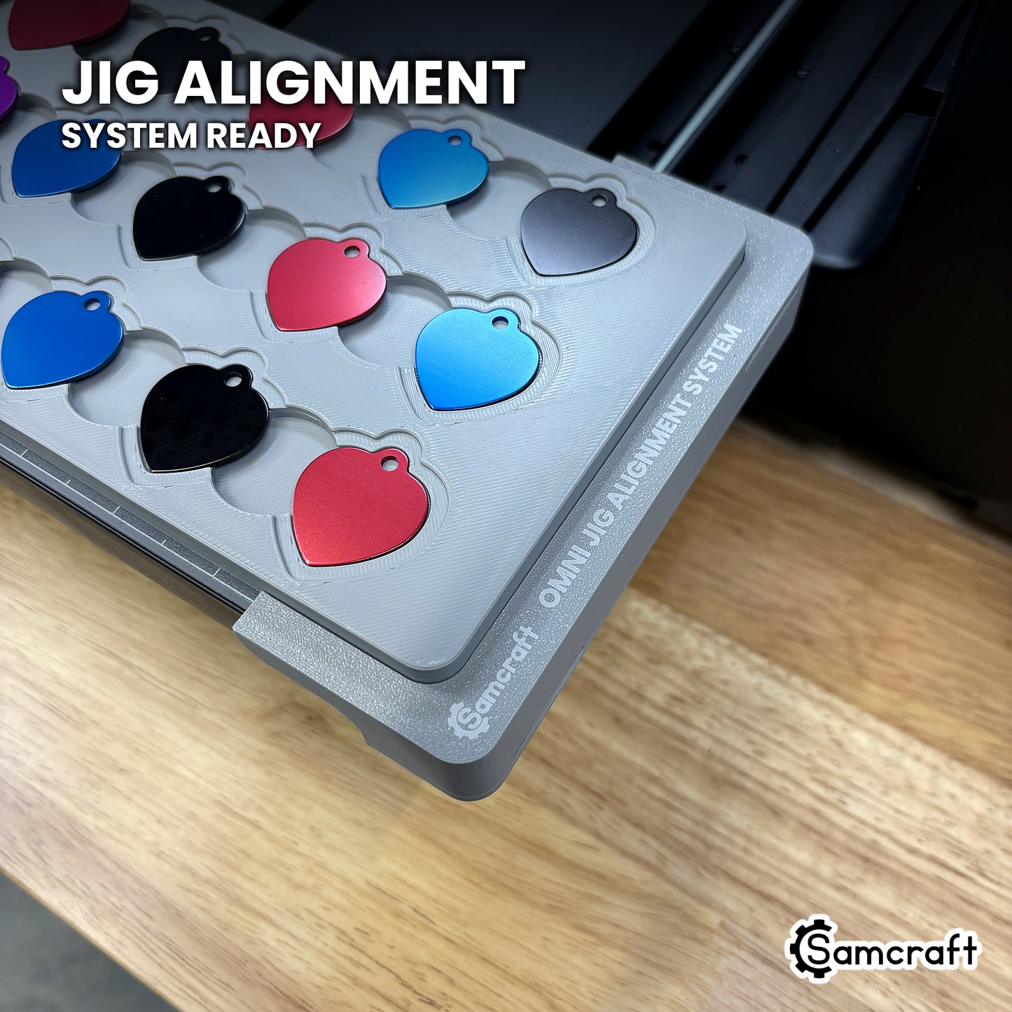 Close-up of the Samcraft heart pet tag jig seated on the Omni Jig Alignment System, the alignment system lettering visible along the edge.