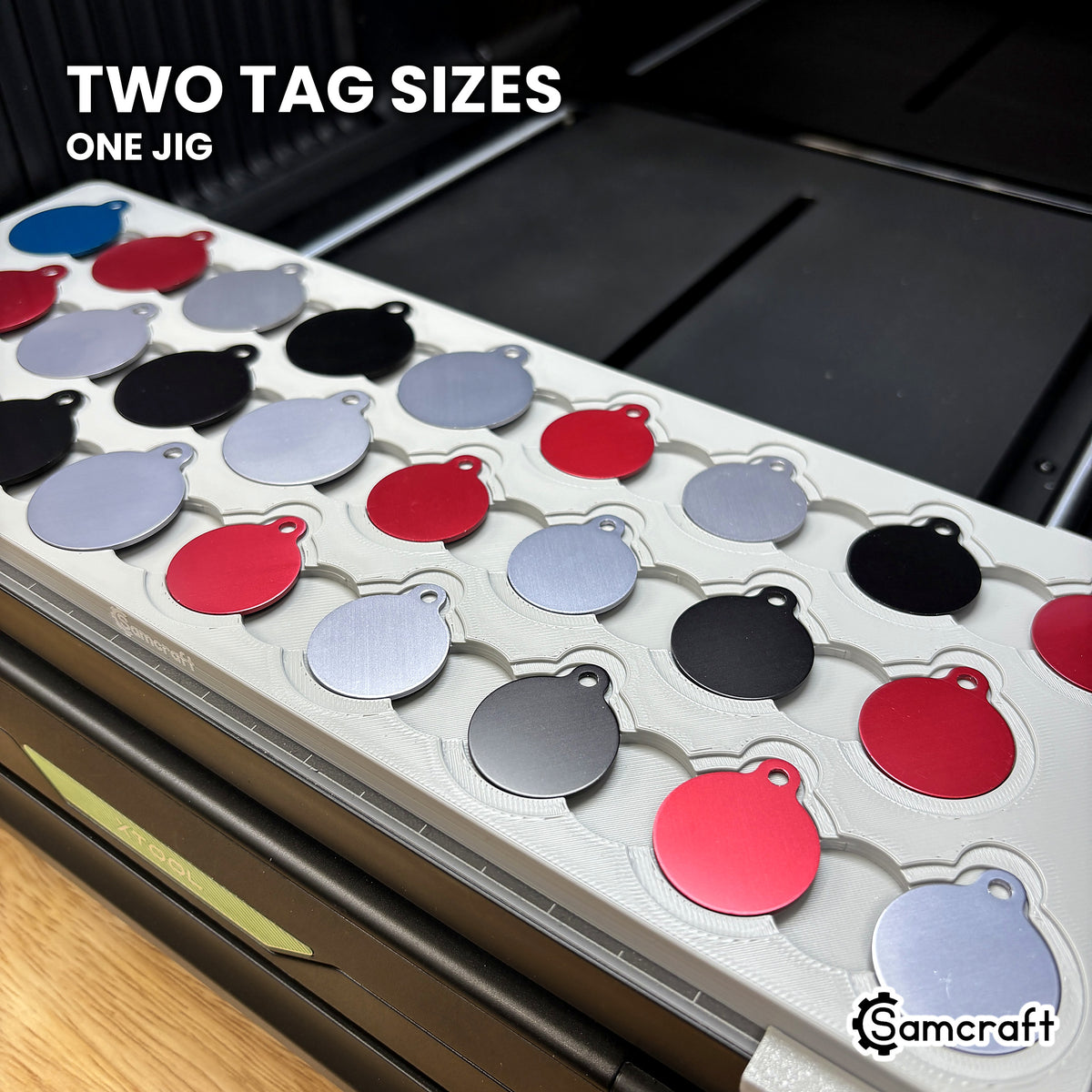 Close-up of the Samcraft round pet tag jig showing both tag sizes seated in nested recesses, the larger tag in the outer step and the smaller in the inner recess.