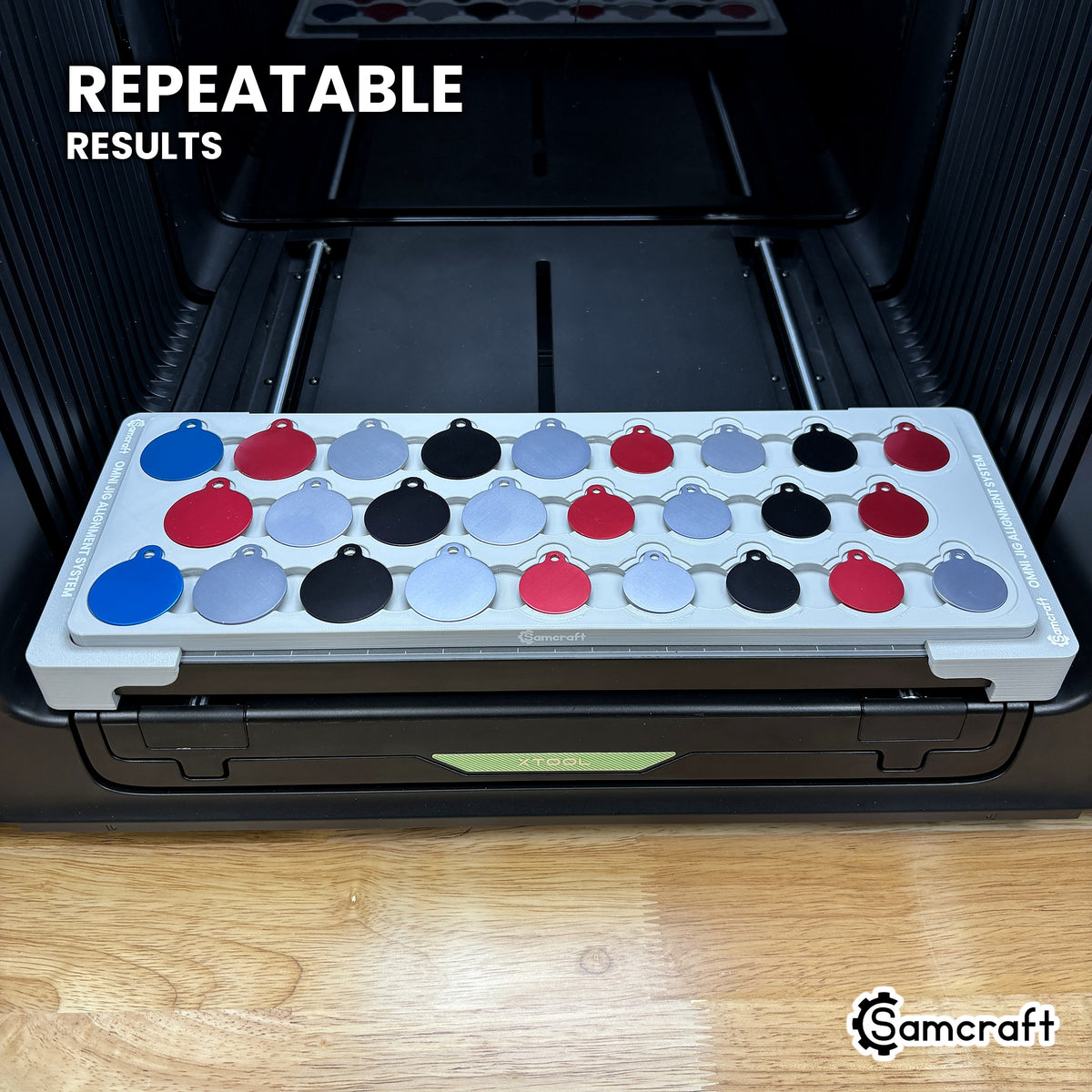 Angled view of the Samcraft round pet tag jig full of colored aluminum tags on the xTool Omni printer bed, for repeatable print placement.