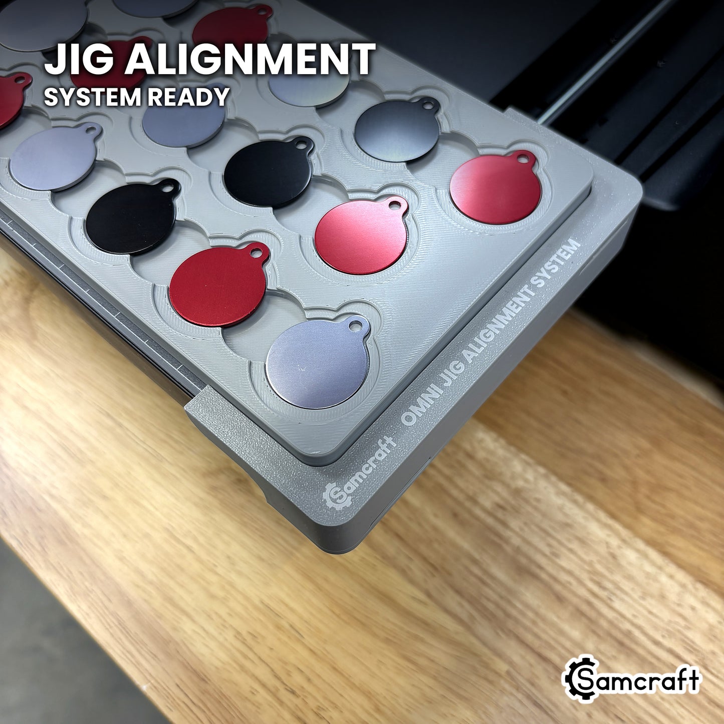 Close-up of the Samcraft round pet tag jig seated on the Omni Jig Alignment System, the alignment system lettering visible along the edge.
