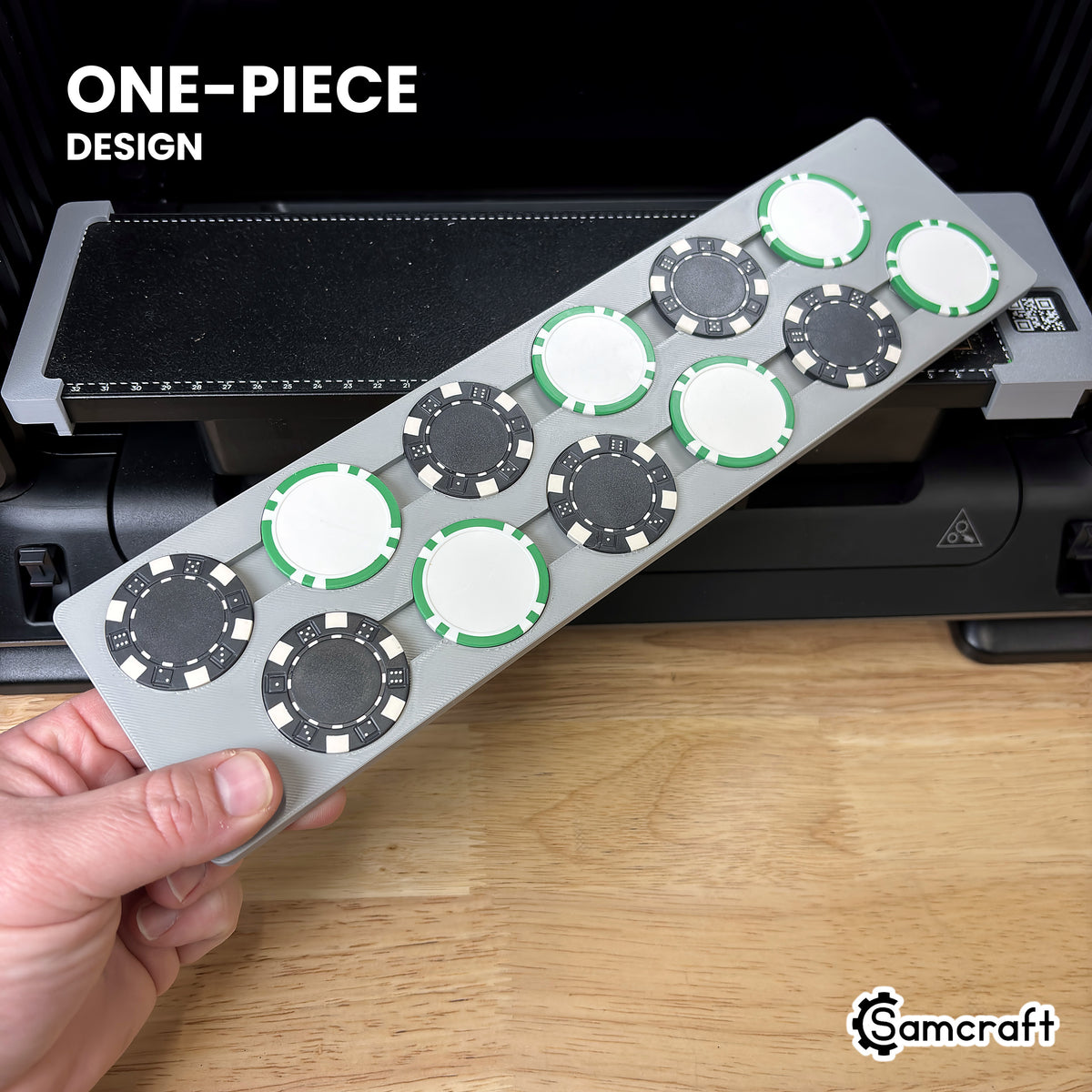 Hand holding the one-piece Samcraft poker chip jig for the eufyMake E1, loaded with 12 poker chips, above the printer bed.