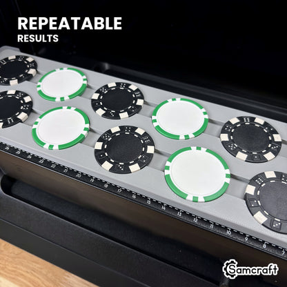 Angled close-up of black and green-striped poker chips lined up in matching pockets of the Samcraft eufyMake E1 jig, every chip in the same position.