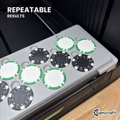 Close-up of black and green-striped poker chips lined up in matching pockets of the Samcraft xTool Omni jig, every chip in the same position.