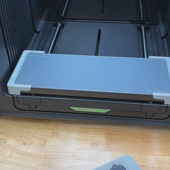 Video of the Samcraft heart pet tag jig for the xTool Omni UV printer being loaded with aluminum heart tags and placed on the printer bed.