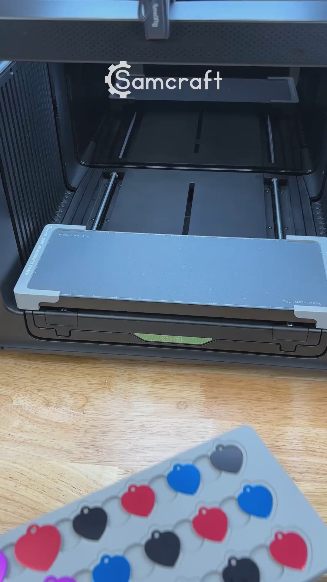 Video of the Samcraft heart pet tag jig for the xTool Omni UV printer being loaded with aluminum heart tags and placed on the printer bed.