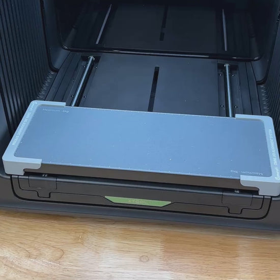 Video of the Samcraft 50mm metal coin jig for the xTool Omni UV printer being loaded with blank challenge coins and placed on the printer bed.