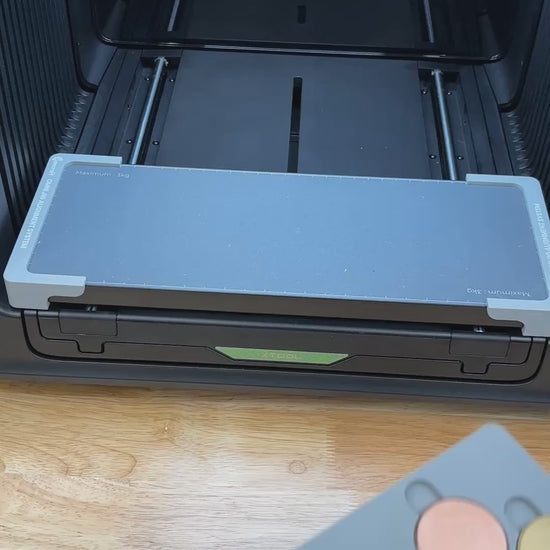 Video of the Samcraft 40mm metal coin jig for the xTool Omni UV printer being loaded with blank challenge coins and placed on the printer bed.