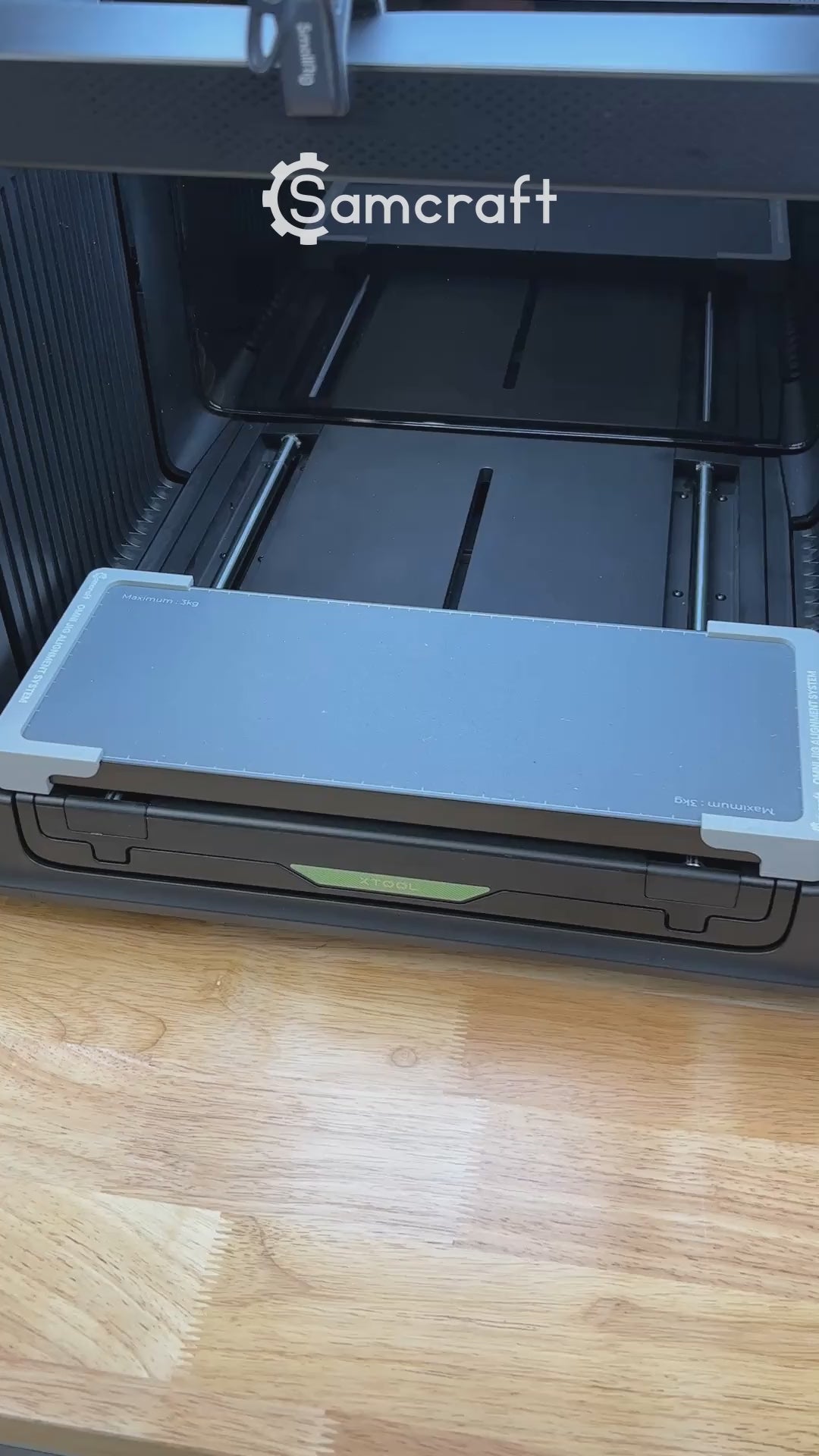 Video of the Samcraft flat metal keychain bottle opener jig for the xTool Omni UV printer being loaded and placed on the printer bed.