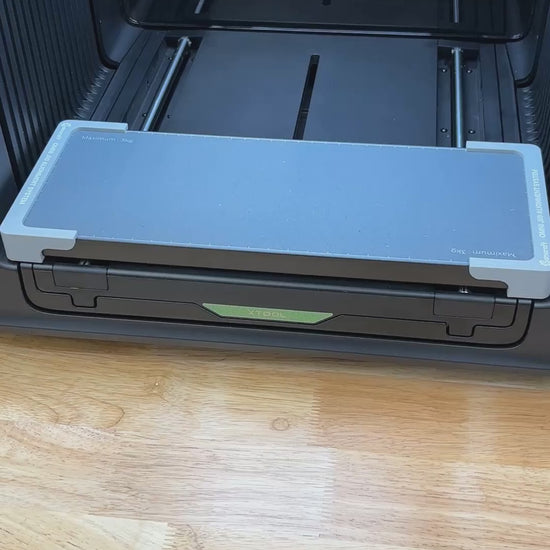 Video of the Samcraft hockey puck jig for the xTool Omni UV printer being loaded with four pucks and placed on the printer bed.
