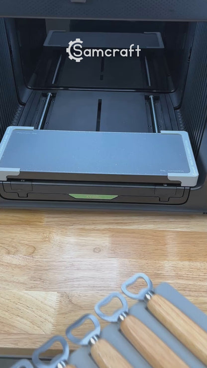 Video of the Samcraft wood handle bottle opener jig for the xTool Omni UV printer being loaded with openers and placed on the printer bed.