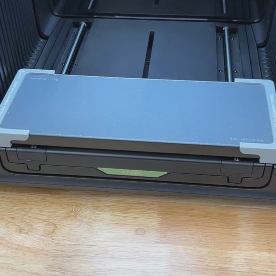 Video of the Samcraft 4 inch drink coaster jig for the xTool Omni UV printer being loaded with slate coasters and placed on the printer bed.