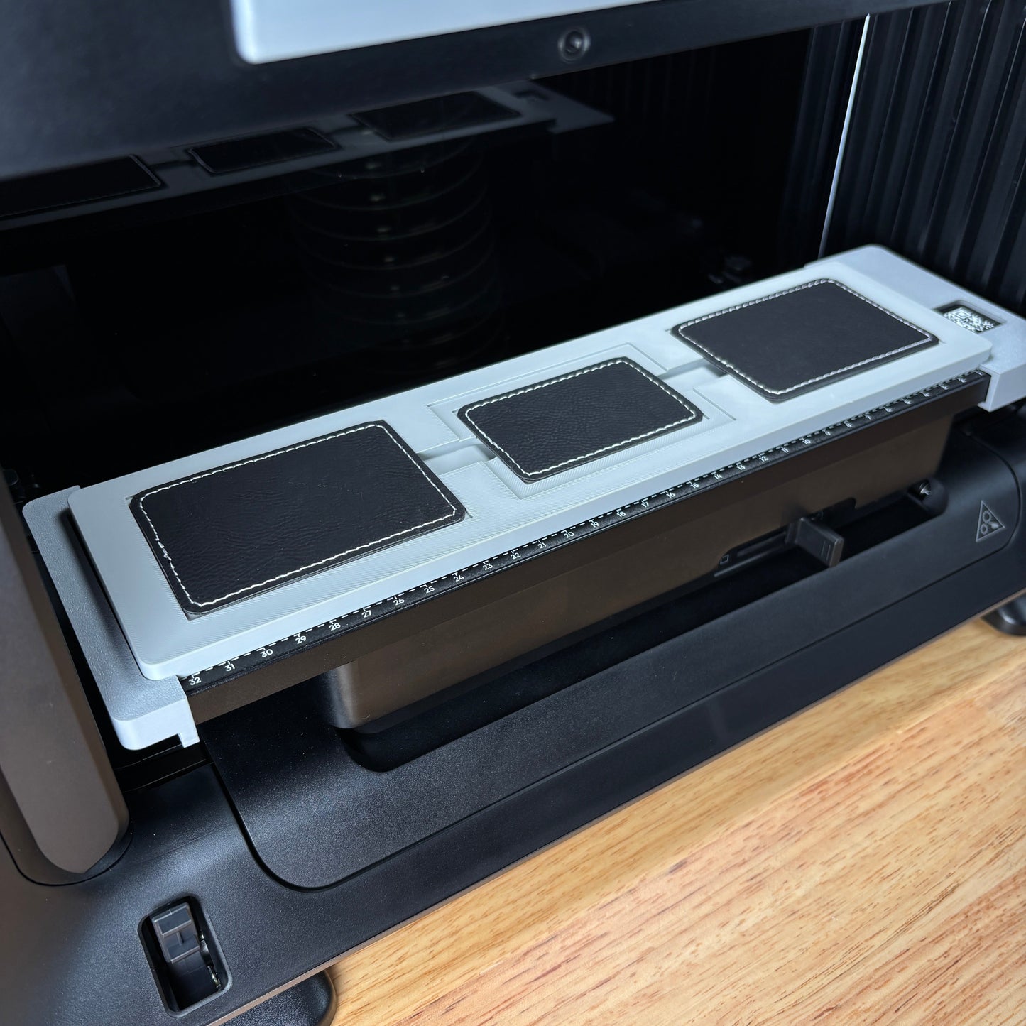Samcraft rectangle patch jig on the eufyMake E1 print bed, holding three black rectangle patches.
