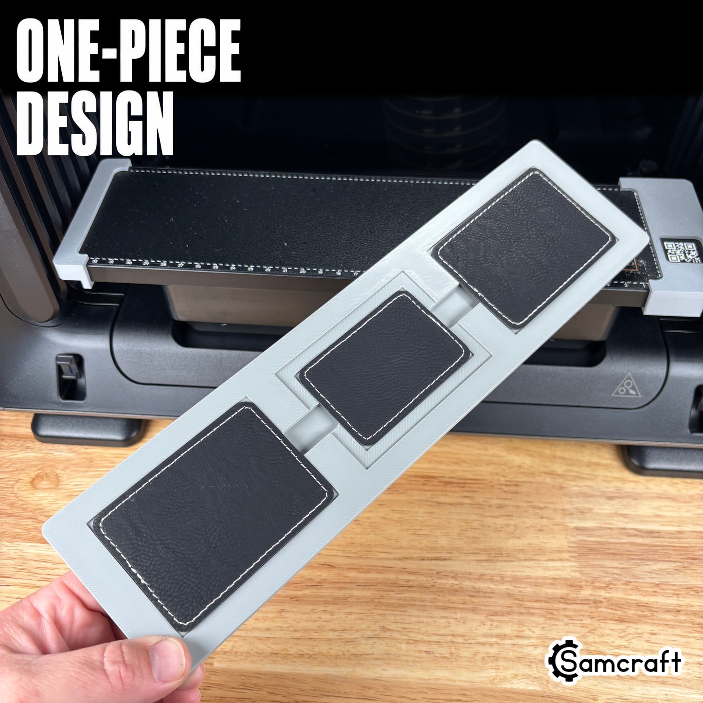 Rectangle Patch Jig for the eufyMake E1 — hand holding the gray one-piece 3D-printed tray with three black stitched leather rectangle patches, template files included, highlighting the one-piece design.