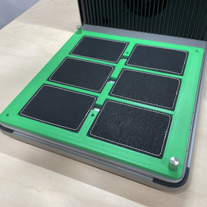 Samcraft green rectangle patch jig in an xTool F1 Ultra laser bed, holding six black rectangular leatherette patches.
