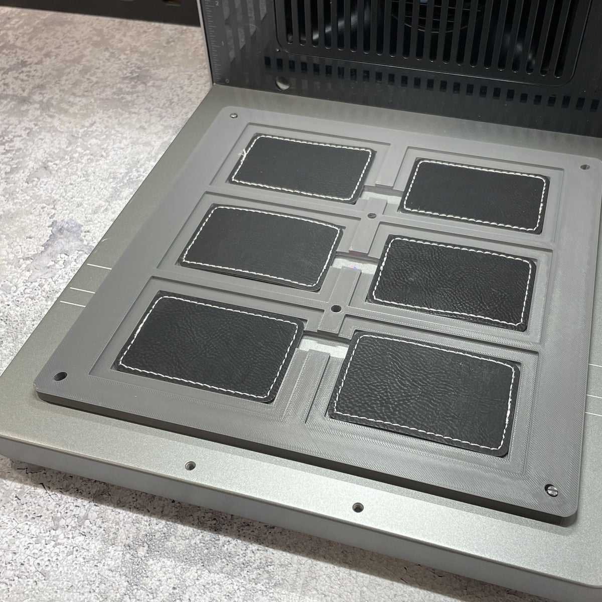 Samcraft rectangle patch jig on the xTool F2 Ultra bed, holding rectangular leatherette patches.