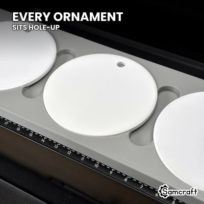 Close-up of a white round ceramic ornament seated hole-up in the Samcraft eufyMake E1 jig, next to the bed's built-in ruler.