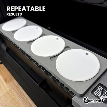 Angled view of the Samcraft round ceramic ornament jig with four ornaments on the eufyMake E1 printer bed, for repeatable print placement.