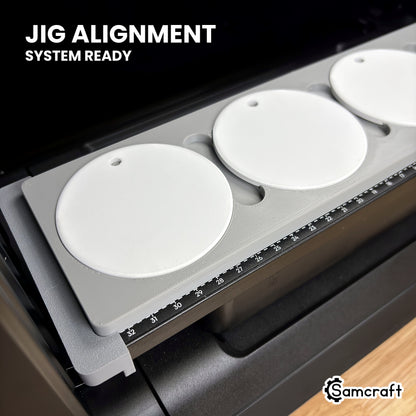 Close-up of the Samcraft round ceramic ornament jig on the eufyMake E1 bed, the gray Jig Alignment System end piece fitted over the end of the bed.