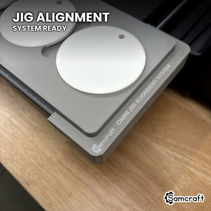 Close-up of the Samcraft round ceramic ornament jig seated on the Omni Jig Alignment System, the alignment system lettering visible along the edge.