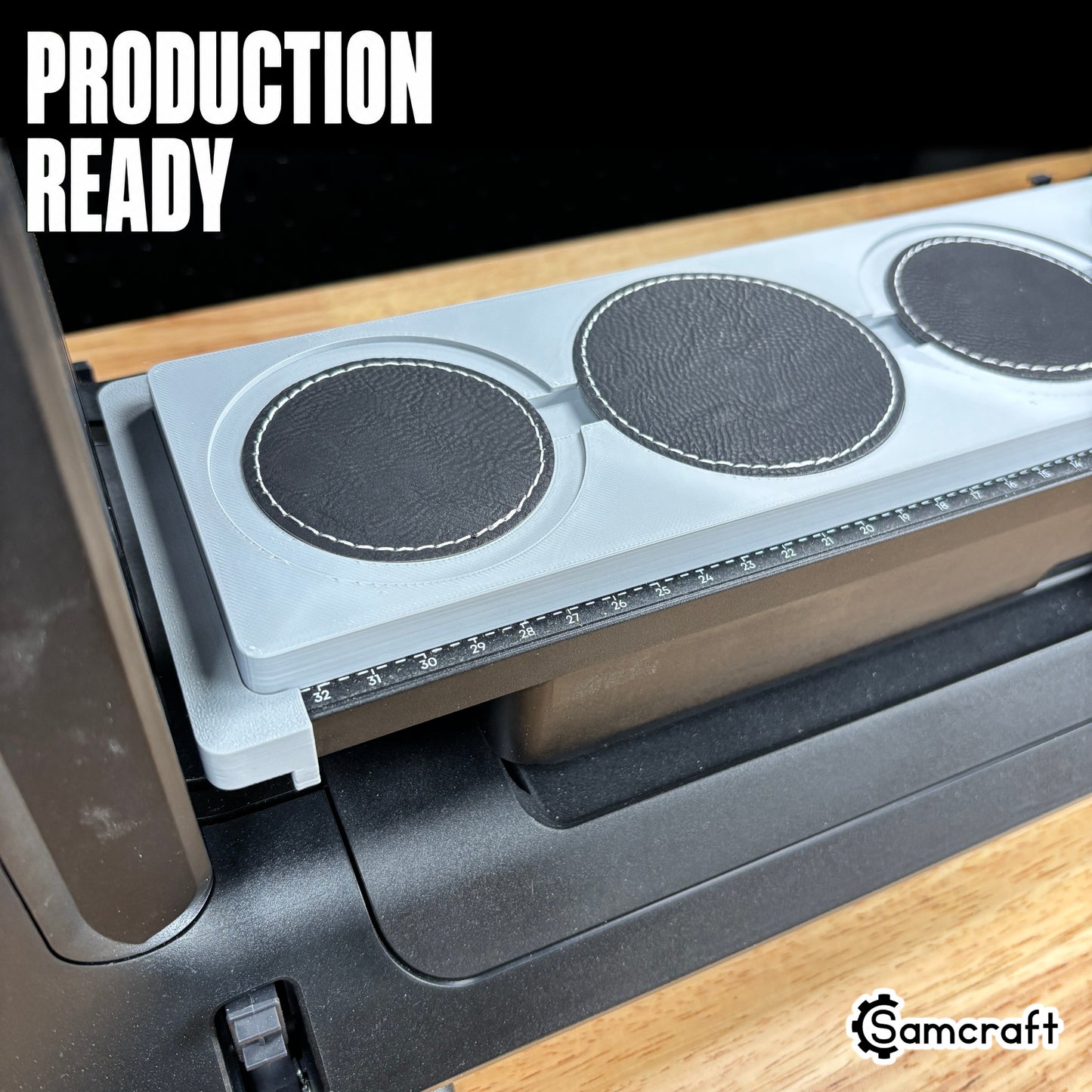Round Patch Jig for the eufyMake E1 — four round black leather patches with white stitched borders lined up in the gray one-piece tray mounted on the printer bed, alignment ruler along the edge, set up for production-ready batch printing.