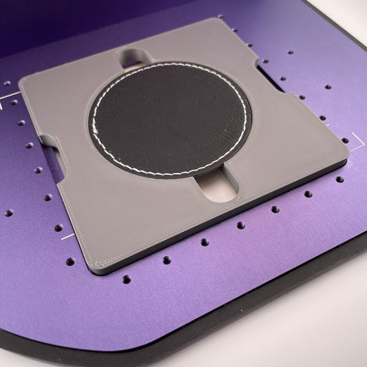 Samcraft round patch jig on the purple bed of a WeCreat Lumos, holding a round black leatherette patch.